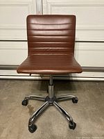 Front view of the brown faux leather office chair showing the padded seat, horizontal stitched backrest, and chrome 5-point caster base