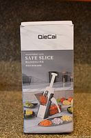 Box of OieCai Safe Mandoline Slicer showing the product image and name with '40+ Different Cuts' and 'Safe Slice Mandoline' printed on front.
