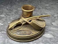 Angled front view showing detailed engraving on rifle and textured hunting hat with match striking base