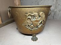 Front angled view showing applied brass eagle motif and lion paw foot detail