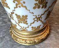 Bottom half of vase showing gilt relief floral motif and ormolu base