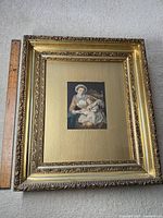 Full view of the gesso frame with lithograph inside, showing frame details and ruler for scale