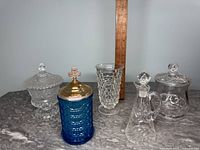 Front view of all five glass collectible pieces displayed in a row with a ruler behind for scale