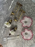 Overview of all components on countertop: two brass sconces, two lamp bodies with burners, two shades, two chimneys