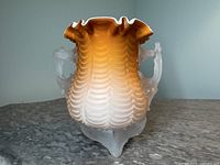 Front and side view of the dark amber to white gradient scalloped rim vase with moiré pattern showing dual frosted camphor handles and tripod frosted footing on marbled surface.