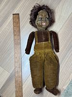 Full view of vintage Norah Wellings cloth doll showing the entire length next to a ruler for scale.
