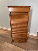 Front view of oak roll front filing cabinet closed