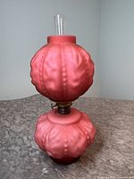 Assembled lamp upright showing pink satin glass body with bead & drape pattern and clear chimney