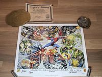 Overview of the signed lithograph print laid flat on wooden floor with certificate of authenticity and some coins around the edges for scale and context.