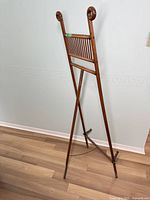 Full front view showing scroll-top uprights, slatted support rail, adjustable crossbar and tripod legs