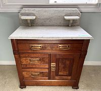 Front view showing walnut case, marble top and backsplash with shelves