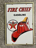 Front view of sign in metal frame showing Fire Chief Gasoline graphics