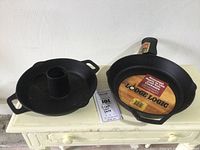 Full view of both cast iron pans showing roaster with central tube and skillet with label