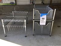 Photo showing two metal storage racks side by side on the floor; left rack is wireframe with drawers, right rack is stackable metal units with mesh drawers