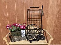 Photo showing all decorative items grouped including wall magazine rack, folding holder, basket, and morning glory flowers in a basket on a wicker shelf