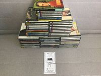 Stack of classical and instrumental music CDs in jewel cases, arranged horizontally and vertically, showing the quantity and some cover art.