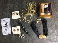Initial overview of all seven pieces arranged including necklaces, earrings, bracelet and watch set.