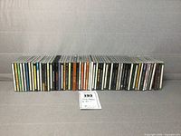 Row of 59 folk and blues music CDs in cases, arranged side by side, visible spines showing various titles and artists.