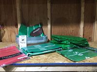 Overview of party supplies including grass pattern tablecloths, football field tablecloth folded, and banner with football motif.