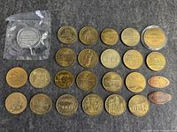 Top view of entire lot: 28 assorted commemorative medals including French souvenir medals, Buckingham Palace, Smithsonian Air and Space, and two pressed pennies.