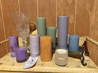 Overview of seven pillar candles, two jar candles, and the candle tray showing their sizes, colors, and condition.