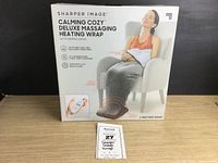 Box of Sharper Image Calming Cozy Deluxe Massaging Heating Wrap showing front product image and key features.