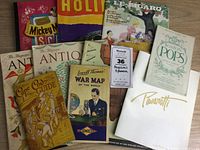 Collection of vintage magazines including Mickey Mouse Spanish magazine, Hollywood magazine, Le Figaro newspaper, two Antique magazines, Cape Cod Guide, Lowell Thomas war map, Boston Pops program, and Tavarotti brochure.