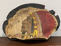 Full front view of painted wood slice showing carved Indian chief profile with bark edge