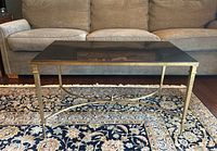 Front view showing black granite top and brass frame