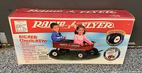 Box front showing kids riding the Classic red Radio Flyer wagon with white logo and visible air tires.