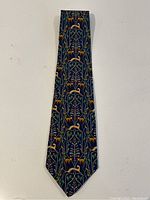 Full view of navy blue silk tie with jungle animals and botanical pattern