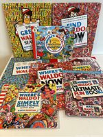 Eight Where's Waldo books displayed together on a surface, titles visible including various 'Waldo' search and activity books by Martin Handford.