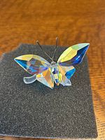 Front view of crystal butterfly figurine showing multi-colored Aurora Borealis wings, clear crystal body, and wire antennae.