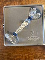 Candleholder inside original Swarovski Silver Crystal box showing the frosted twisted crystal stem, blue crystal beads, and the faceted flower top.