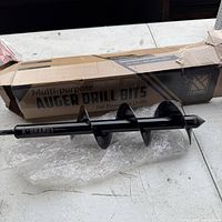 Full view of one multi-purpose auger drill bit alongside original box packaging