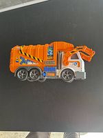 Side view of orange and white Big Dickie Toys recycle garbage truck with detailed decals and six wheels