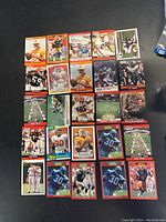 Top view of 24 football cards laid out on a flat surface showing front sides.