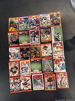 Top down view of 25 football trading cards laid out in a 5x5 grid arrangement showing various players, teams, and card designs.