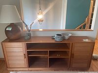 Front view of central console module with open shelving and flanking slatted-door cabinets