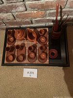 Full tea set displayed on black tray with bamboo mat, showing teapot, pitcher, cups, and holder for tools