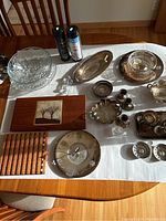 Overview of assorted entertaining dishes including glass, silver-tone items, and wooden cutting boards on a table