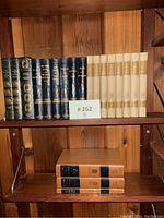 Shelf with Ernest Hemingway hardcover books and vintage book sets, showing titles and bindings.