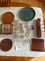 Full overview of all items on table, showing napkin rings, trivets, and decorative plates