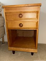 Full view of oak nightstand showing two drawers and open bottom shelf.