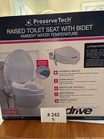 Box front showing PreserveTech raised toilet seat with bidet, highlighting key features such as ambient water temperature and retractable bidet nozzle.