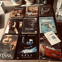 Nine DVD movie cases arranged on a table including The Missing, Live Free or Die Hard, The Ring, Sum of All Fears, King Kong, Finding Nemo, Remember the Titans, Heat, and Cars.