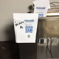 Close-up image showing the metal frame edge and auction tag labeled 'Mirror A'