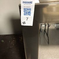 Close-up photo of mirror's brushed metallic frame corner showing texture and finish