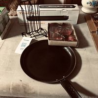 Black frying pan, metal cup holder rack, box of heart-shaped cookie cutters
