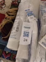 Rolls of white fabric bundled with sewing notions including trims and small packs